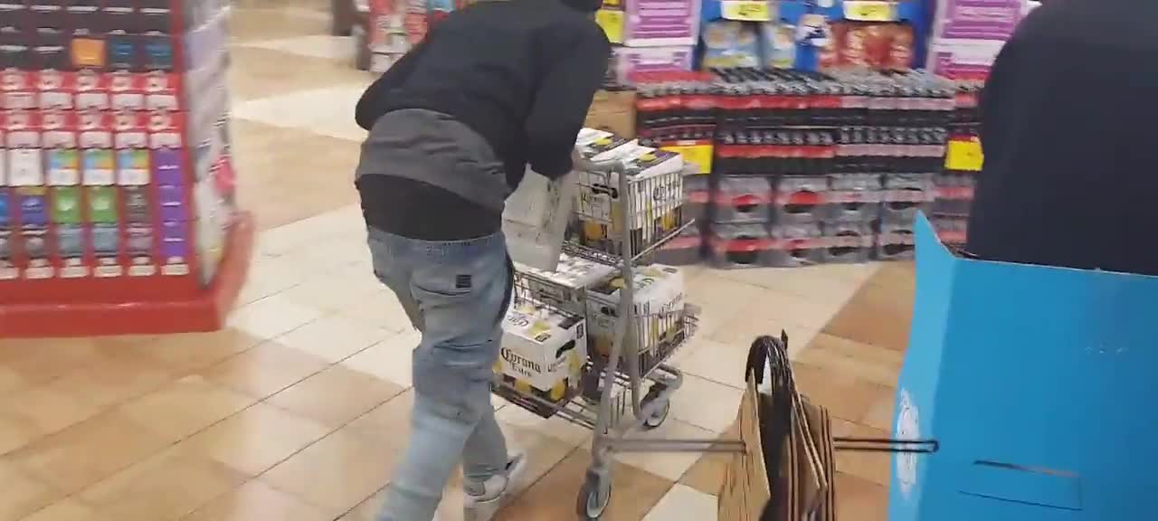 A homeless Seattle man walks out of a store with a loaded cart full of beer without paying