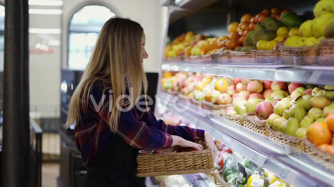 Female Worker In Black Apron Arranging Apples In Supermarket