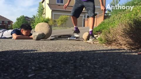 Kid tries to break scooter with big rock and accidentally hits friend