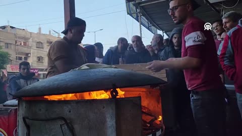 Palestinian volunteers distributed free bread to Palestinians by baking bread on wood fire