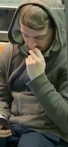 Guy in grey hoodie sweater picking nose eating