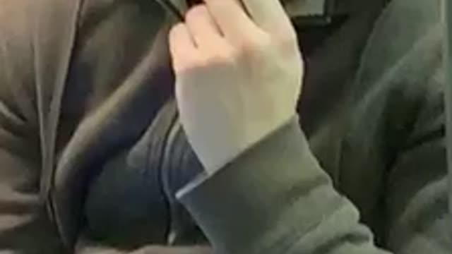 Guy in grey hoodie sweater picking nose eating