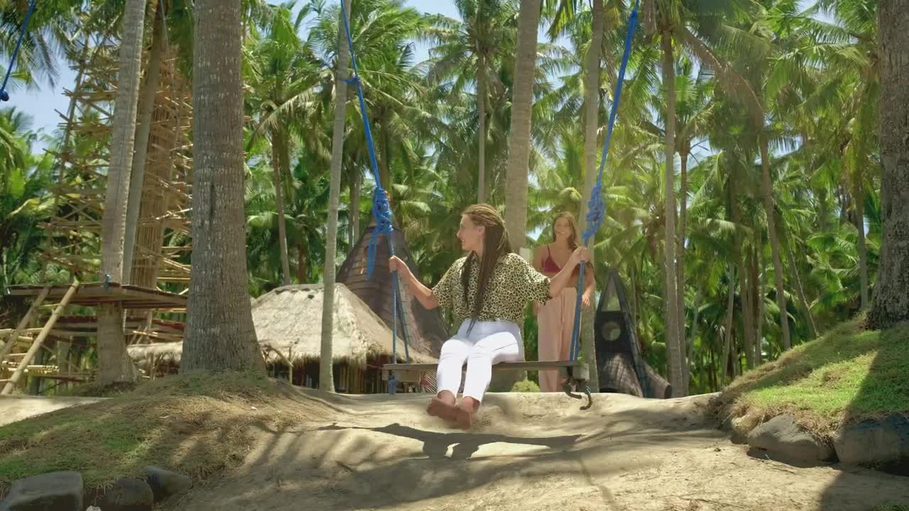 Woman swinging her friend on the beach