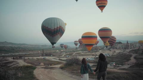 A Couple Walking Towards The Launching Area Of The Hot Air Balloons Festival