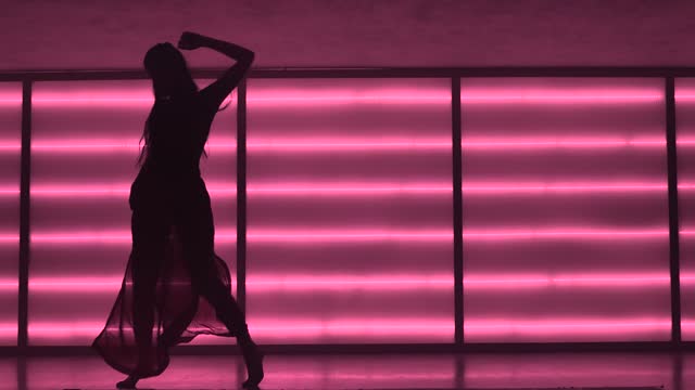 Contemporary dancer in neon-lit studio