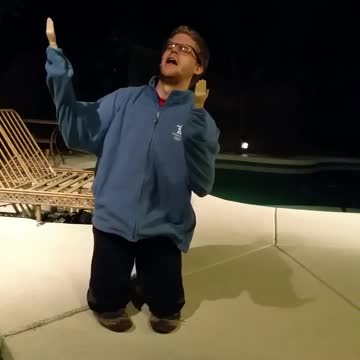 Man On Knees With Doll Hands Does Exuberant Lip Sync To Christmas Song