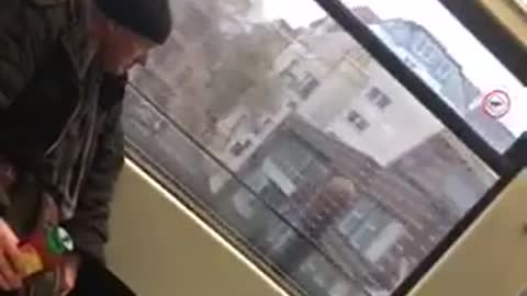 Man drinking straight from red green bottle train