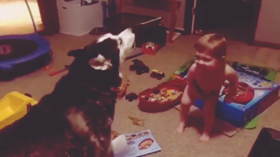 The child is teaching his dog to sing. Check out their duet