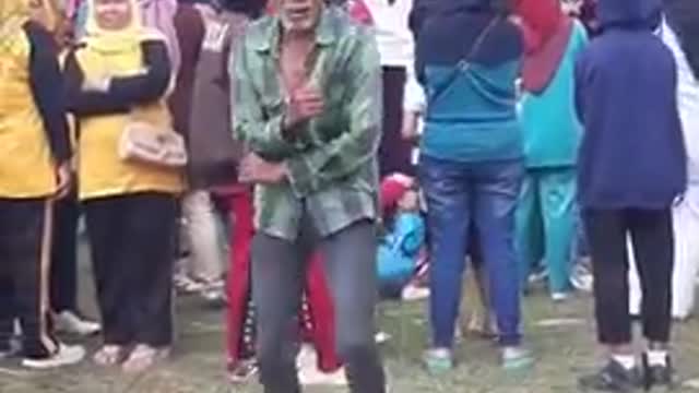This old man is engrossed in dancing to a typical Indonesian dangdut song.