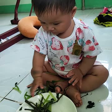Baby learns to eat green vegetables