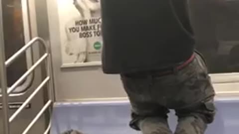 Homeless man does pull ups on subway train