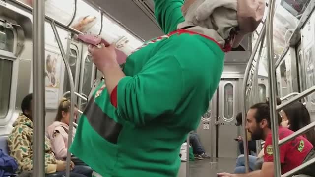 Green shirt elf jollycat sings on subway