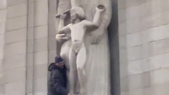 Man climbs onto the BBC building smashing up the Eric Gill pedophile statue