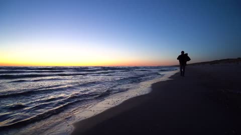 Man walking on the beach with a backpack