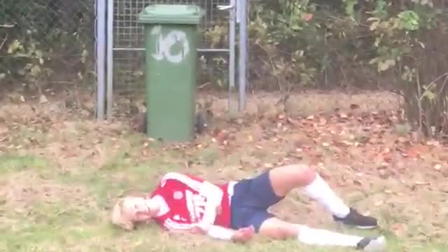 Red shirt kid tries to jump over green trashcan falls