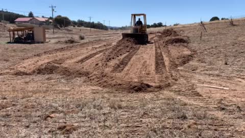 Caterpillar D4C building a dirt pad