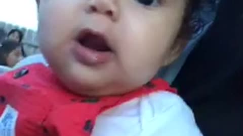 Baby in red overalls throws up on itself