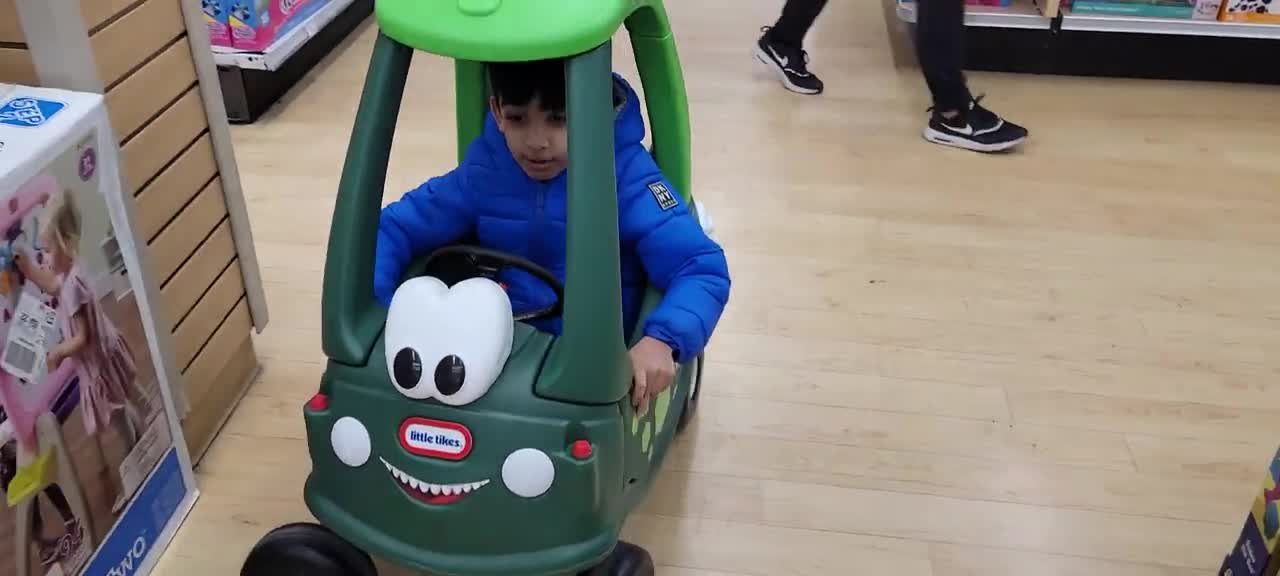 Two small baby enjoy car driving at kids playing station.