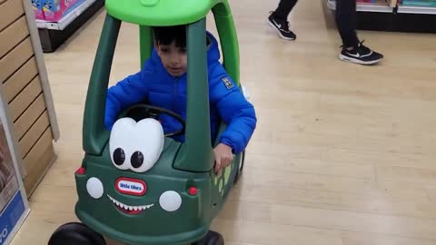 Two small baby enjoy car driving at kids playing station.