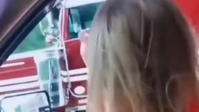 The little girl cheered for the truck driver and the truck driver responded by dancing excitedly