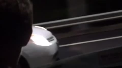 A guy drops his phone outside a car