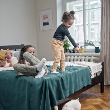 * The little girl is playing on the cat's bad