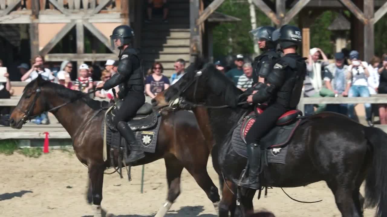 Kopachiv, Ukraine. Four policemen in uniforms riding on horses. Medieval historical combat festival