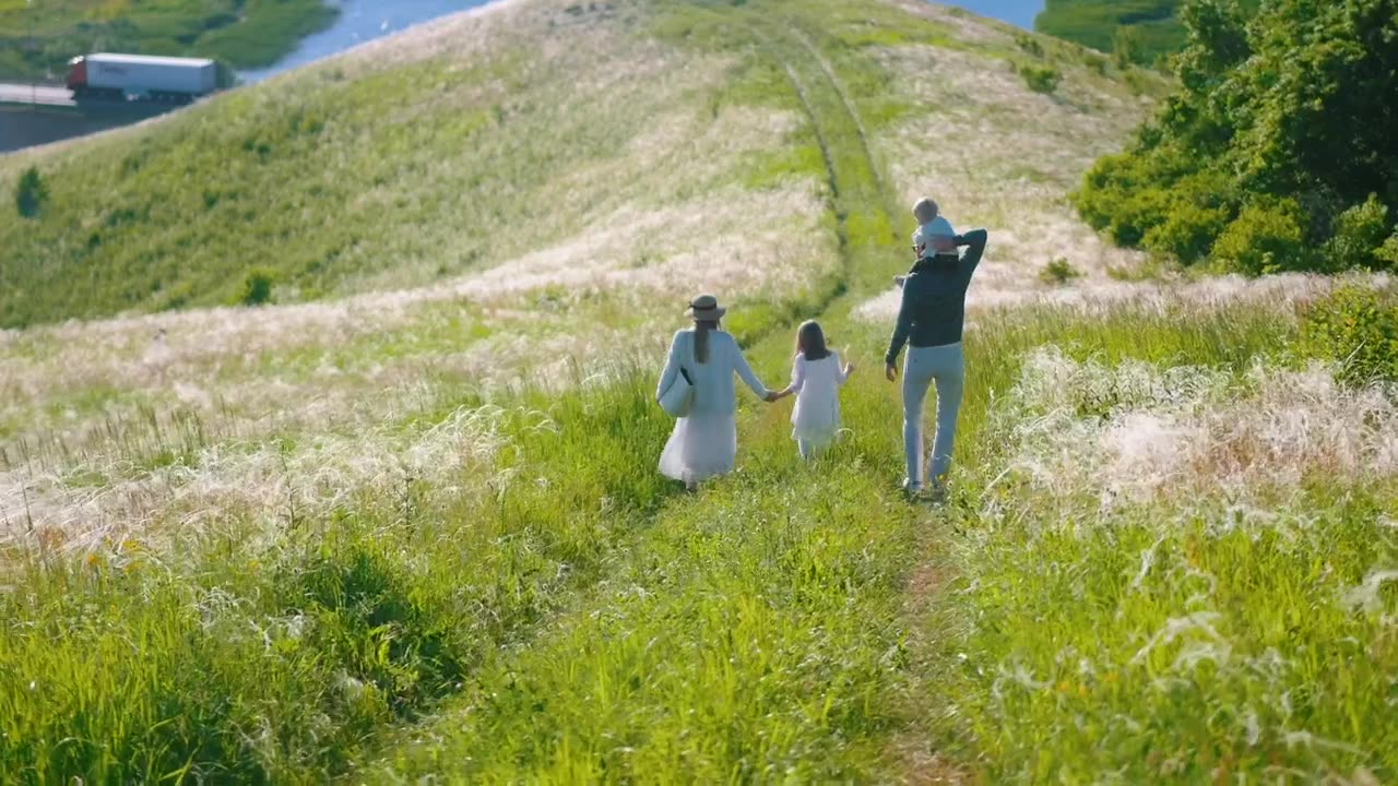 Young family walking on a road at the hill