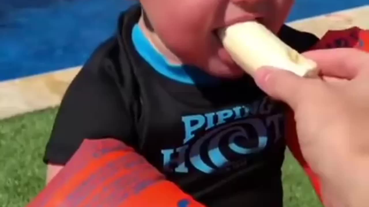 Child tries to eat a banana but fails