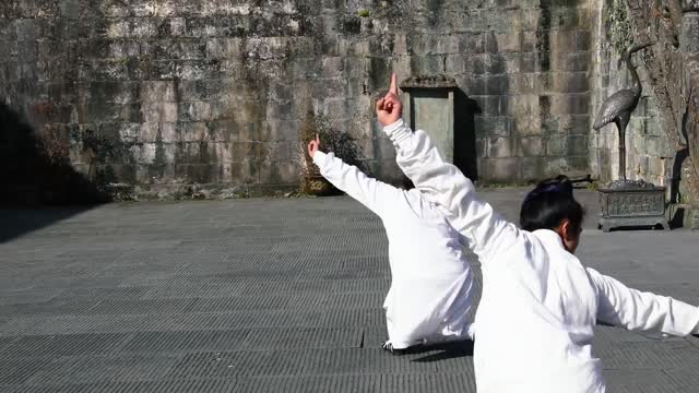 Wudang disciples practice kung fu and dance swords against the rising sun