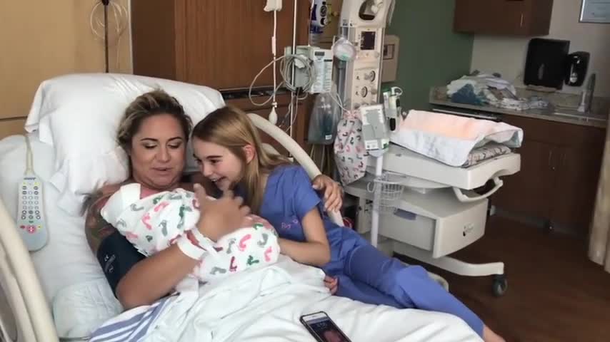 Little girl excitedly meets her newborn baby brother