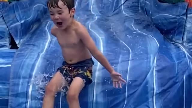 Kid Slides Down Inflatable Water Slide