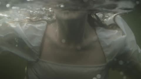A Woman Swimming Underwater In A Lake