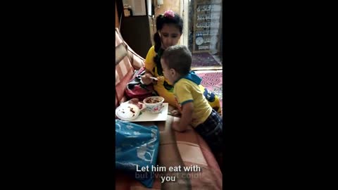 A girl feeds her brother in a funny way