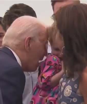 Close up: Biden nibbles on frightened young girl during trip to Finland