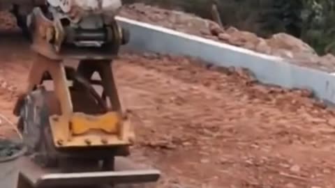 Pressing dirt construction road with excavator