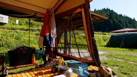 A family with three people camping in the rain