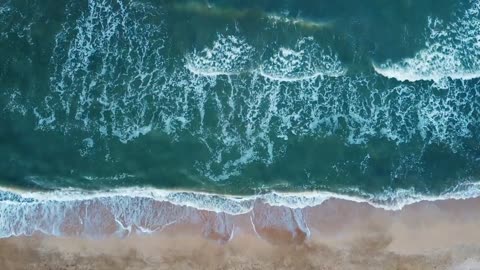 Aerial view of sand beach. Top view sea waves. Drone footage