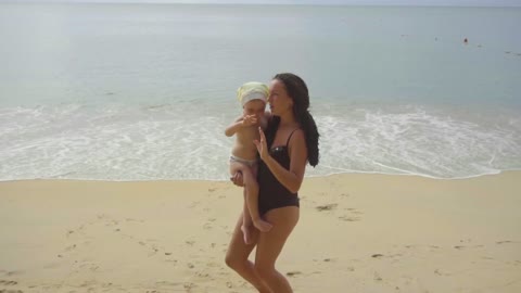 Mom and daughter dancing in the beach