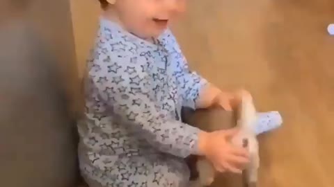 Cute baby playing with a puppy