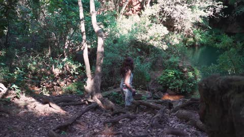 A Woman Taking a Photo of a Forest Lagoon