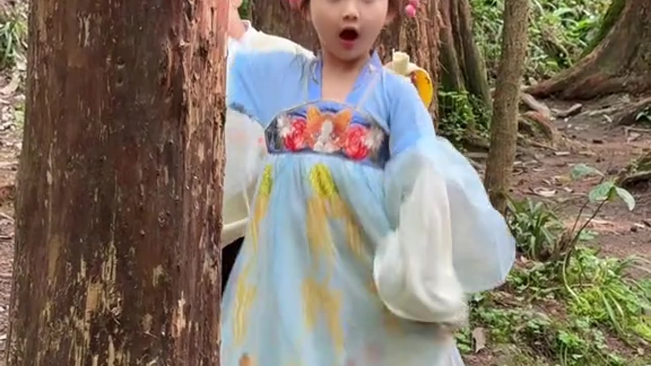 Cute baby dancing behind a tree