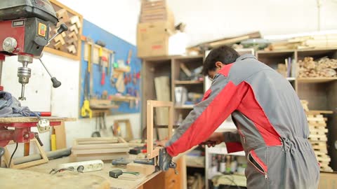 A Man Working In A Wood Workshop Making Frames