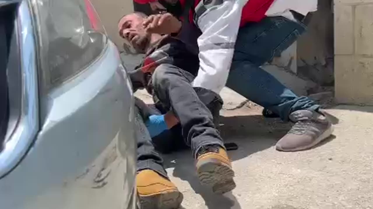 Palestinian Medic rescuing injured man under israeli fire