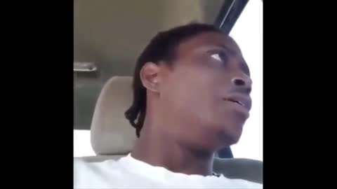 Black Man laughing in the car wit a blunt