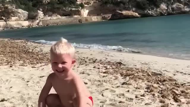 Happy Kid Attempts Straddle Press to Handstand at Beach