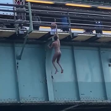 INSANE video shows naked man dangling by one arm from a 6 train station in the Bronx.