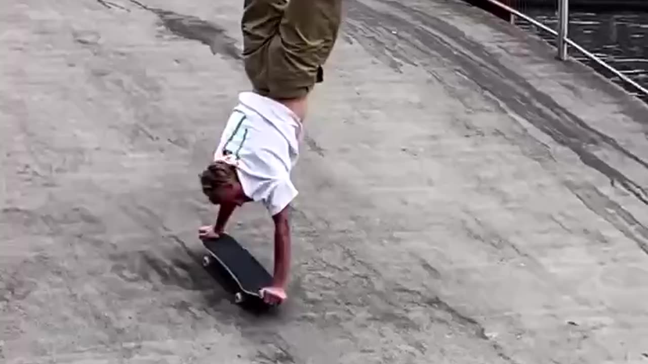 dude shows incredible balance doing rolling handstand on skateboard