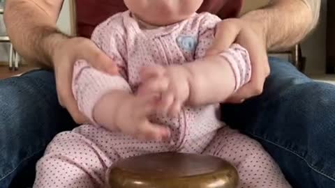 cute baby playing drums with daddy