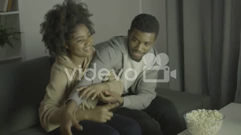 Young Couple Fighting For Remote Control And Having Fun 1